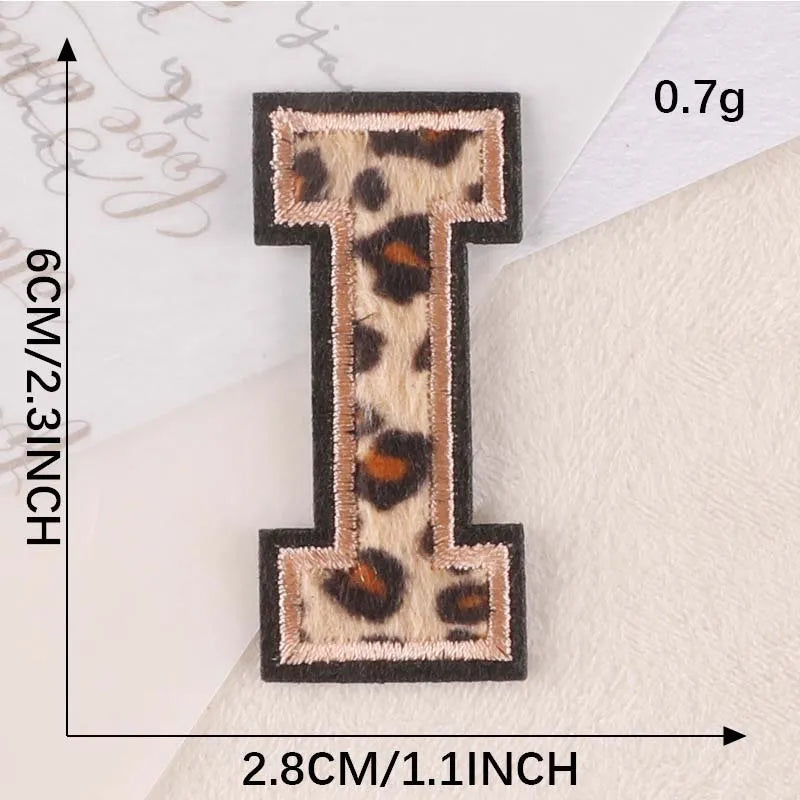 A black iron-on patch shaped like the letter I in leopard print on a white background.