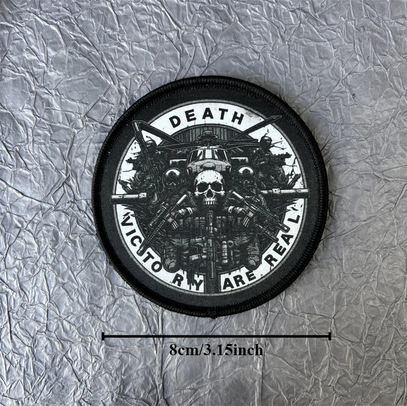 A black tactical skull patch hook and loop badge with white text reading Death Victory Are Real