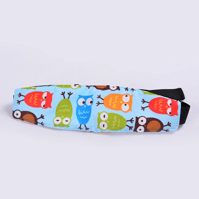 A colorful fabric head support for a baby car seat featuring cartoon owls and other woodland animals.