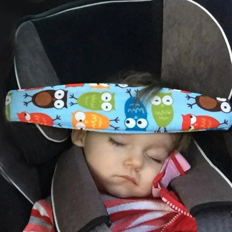 A baby is resting in an adjustable car seat with a colorful head support featuring owl designs.