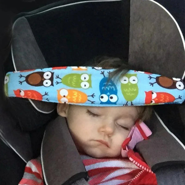 A baby is resting in an adjustable car seat with a colorful head support featuring owl designs.