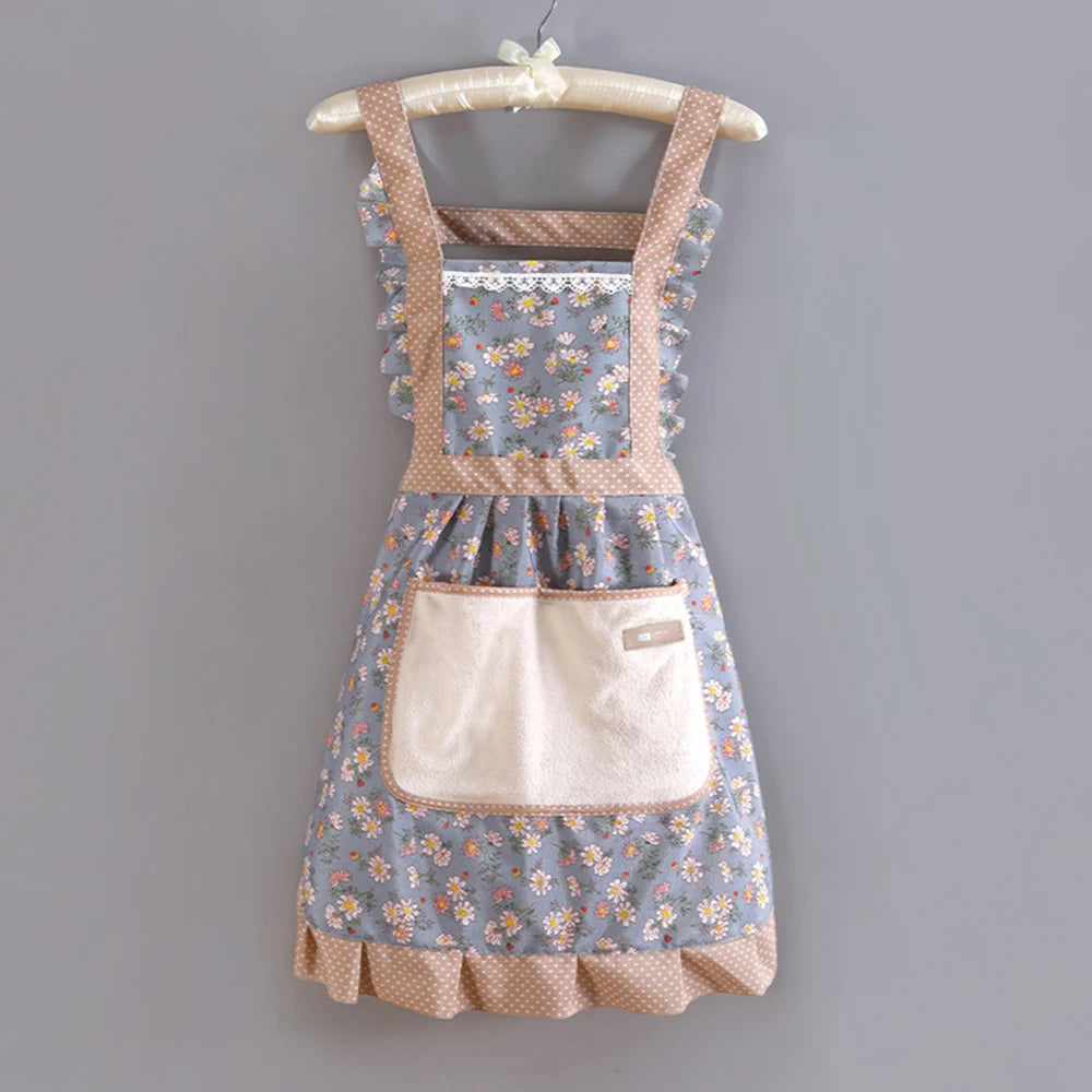 A floral pattern kitchen apron with adjustable straps and a cream-colored pocket, displayed on a hanger.
