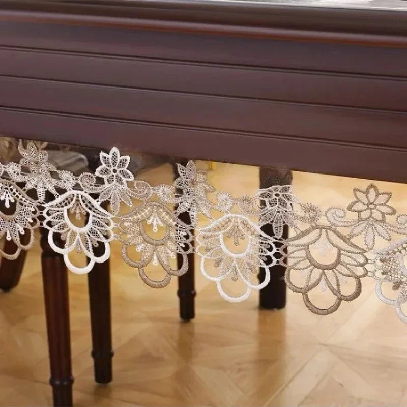 White lace embroidered tablecloth with a waterproof finish displayed on a wooden table.