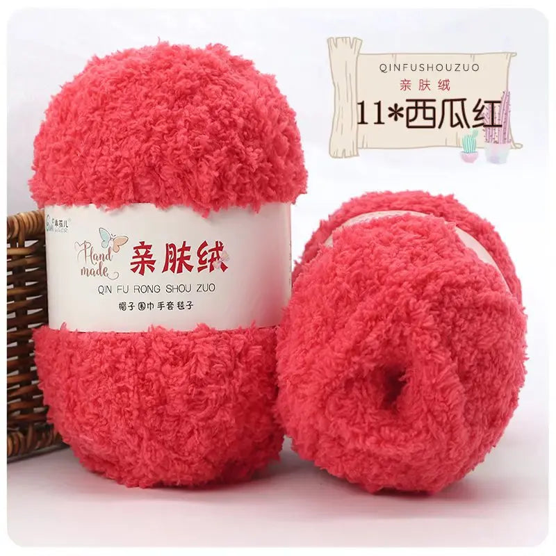 A display of bright pink coral velvet yarn balls for crafting, packaged with a label and bamboo stick.