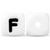 A white silicone alphabet bead shaped like the letter F, shown next to a blank bead.