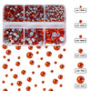 A clear plastic tray holds various sizes of orange and red glass rhinestones for crafts and apparel.