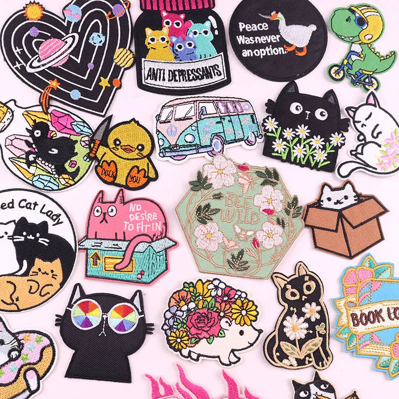 A collection of embroidered cartoon cat iron-on patches featuring various styles and expressions.