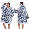A woman models an oversized leopard print fleece hoodie with a white sherpa lining.