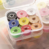 A clear plastic container holds various rolls of assorted colored embroidery sewing threads.