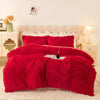 A vibrant red plush duvet cover set displayed on a bed with white linens and bedside tables.