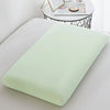 A light green ice silk cooling pillowcase resting on a white surface.