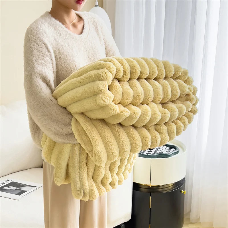 A person is holding a large, fluffy, pale yellow plush blanket with thick, ribbed texture.
