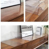 A clear PVC table protector mat is shown on a wooden cabinet surface.