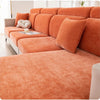 An orange elastic sofa cover with a full backrest shown on a modern sofa.