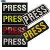 A collection of five embroidered press armband patches in various colors including white, yellow, and red.