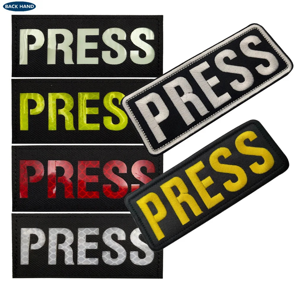 A collection of five embroidered press armband patches in various colors including white, yellow, and red.