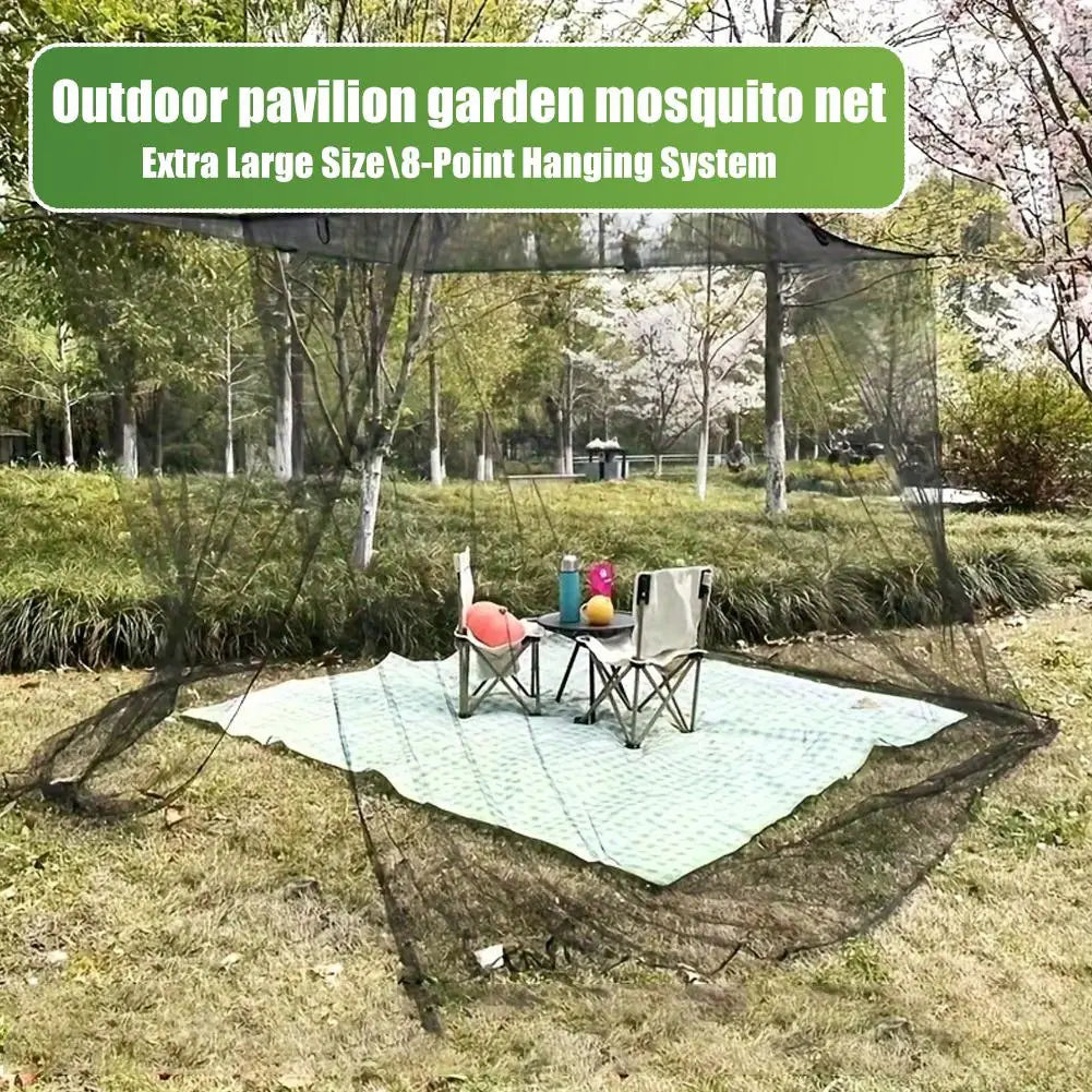 Green mosquito net with an eight-point hanging system set up over a table in an outdoor garden area.