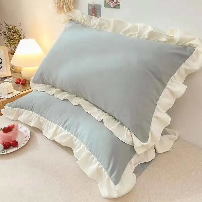 Light blue ruffled princess pillowcases with a hidden zipper displayed on a bed.