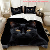 A black cat face print on a blanket displayed on a bed with white bedding.