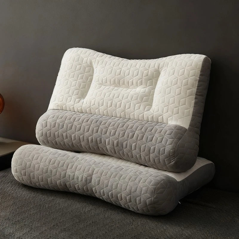 A stack of three beige quilted ergonomic contour pillows for neck and spine support resting on a gray carpet.