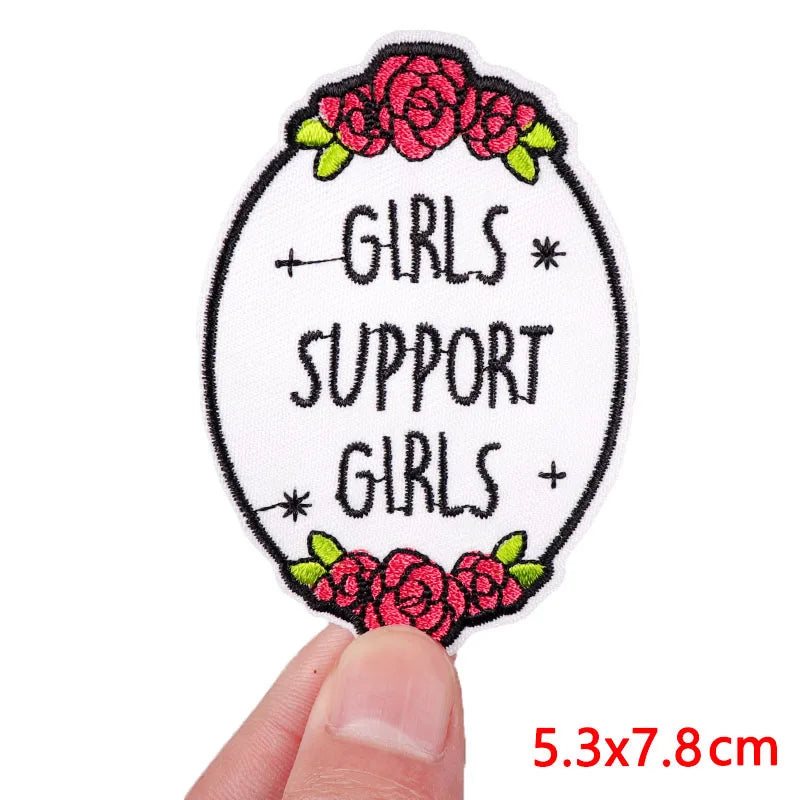Pink letter embroidered iron-on patch featuring a floral wreath design with the text Girls support girls