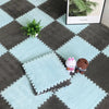 A light blue interlocking puzzle rug mat featuring a dark gray grid pattern with small plush animals and a green plant.