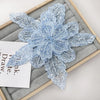 Light blue floral lace applique fabric patches with sequins displayed on a wooden tray.