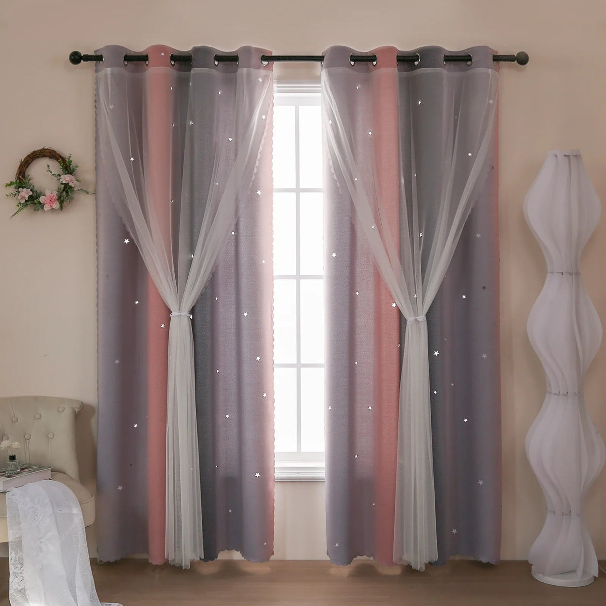 Grey and pink gradient star perforated curtains hanging in a window frame.