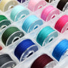 A collection of assorted sewing thread bobbins in various colors and shades arranged in a clear plastic container.