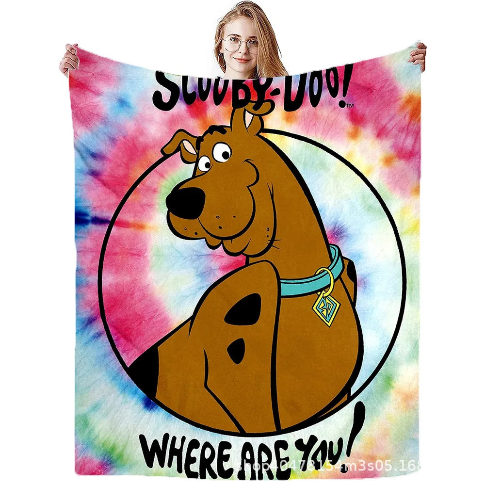 A person holds up a Scooby-Doo themed flannel throw blanket featuring the cartoon character.