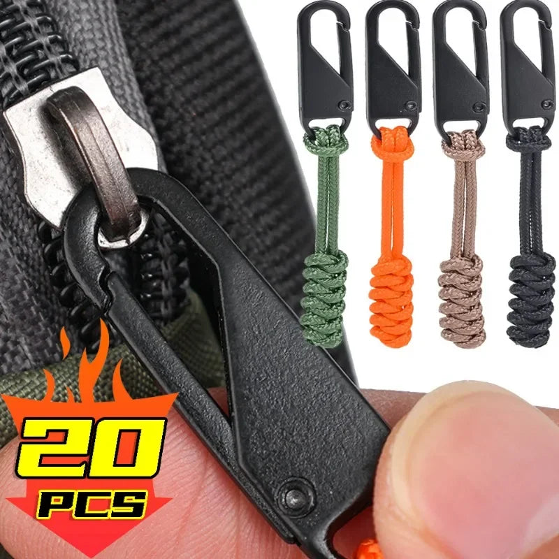 A set of five black detachable zipper pulls with colored cord ties shown against a black fabric background.