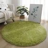 A round, bright green shaggy area rug placed on a light wood floor next to a sofa and a potted plant.