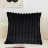 A black faux fur stripe decorative throw pillow cover displayed on a light-colored sofa.