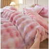 A close-up of a pink plush rabbit quilt comforter being held, showing its soft texture and pink and white mottled pattern.