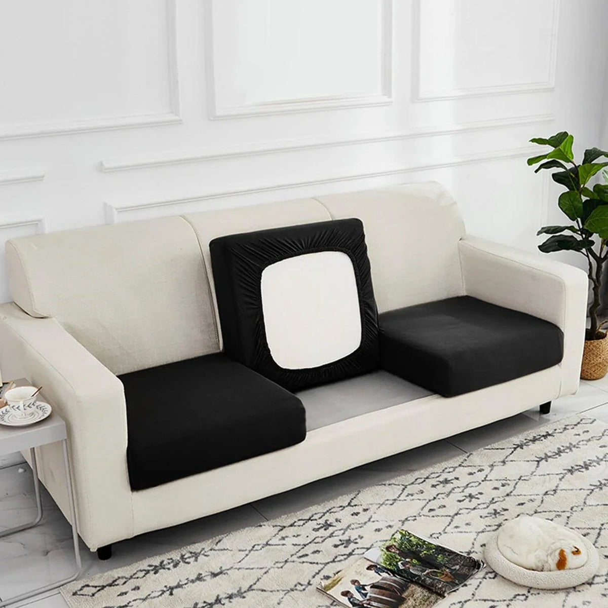 A cream-colored luxury silk elastic sofa slipcover with black cushions and a white accent pillow.