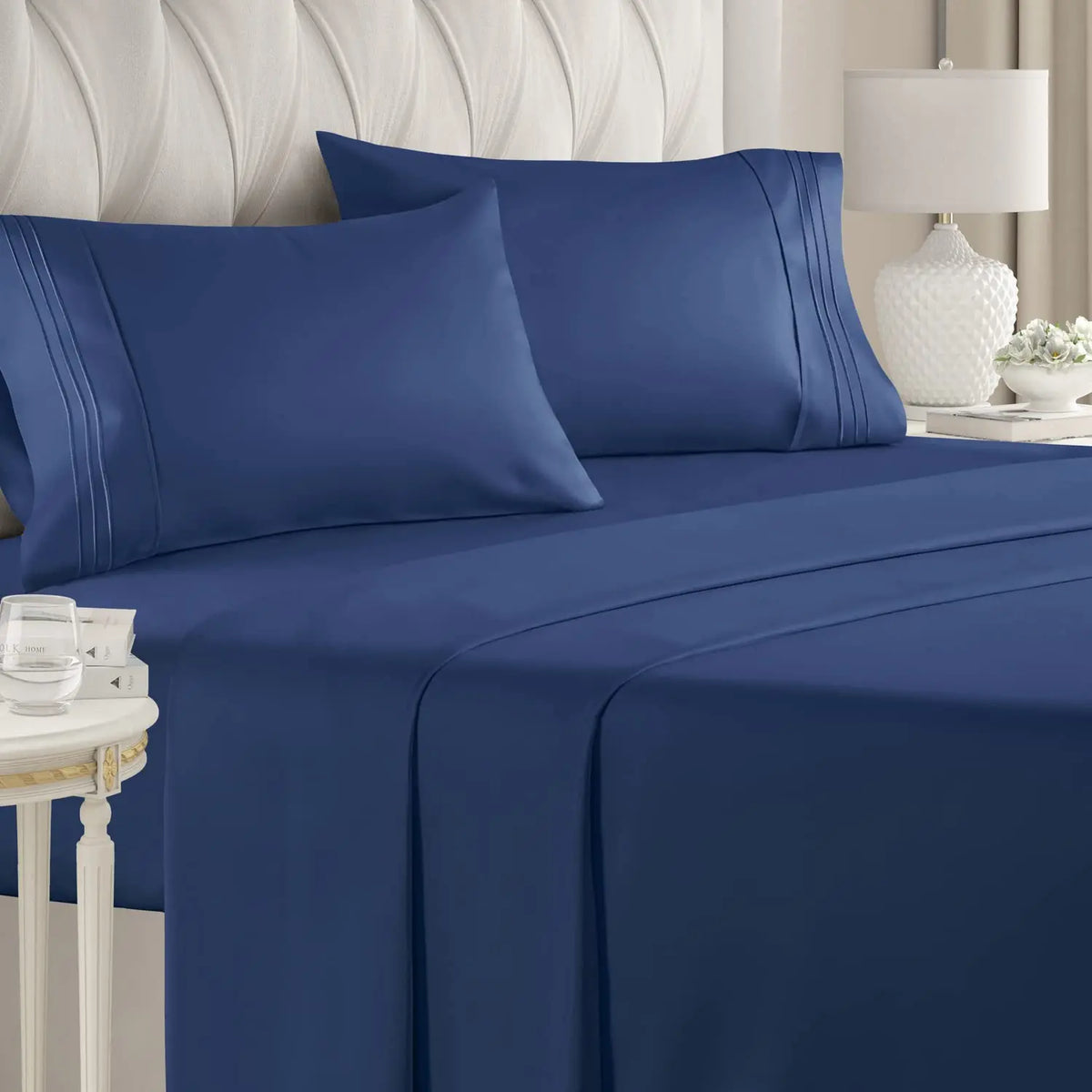 A navy blue luxury microfiber 4-piece bed sheet set with deep pockets displayed on a bed.