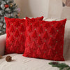 A close-up of a red knitted cushion cover featuring a pattern of small green star Christmas trees.