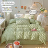 A light green textured duvet cover set displayed on a bed with pillows and decorative items.