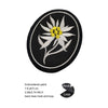 Black embroidered patch featuring a white and yellow flower design with a stem, with a hook and loop backing.
