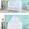 White infant cot with a sheer pink mosquito net canopy displayed in a light teal nursery room.