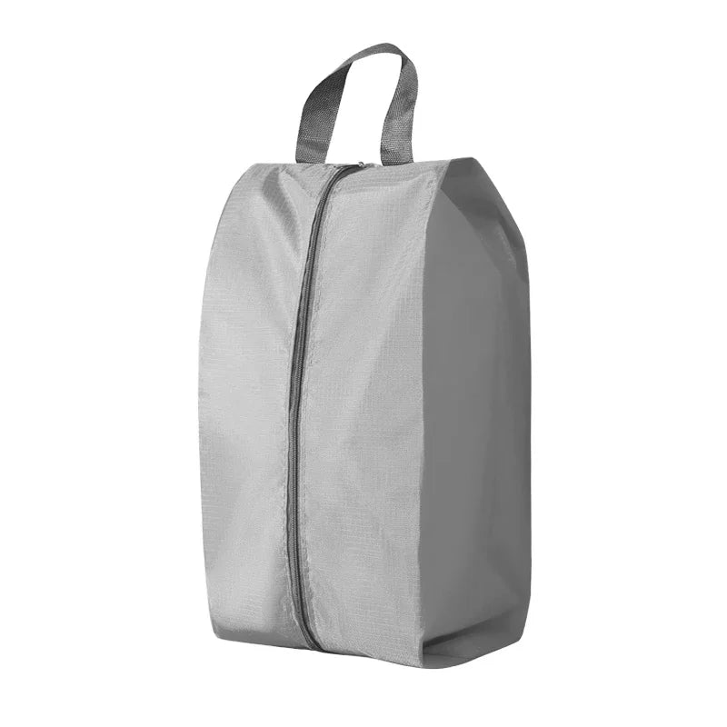 A gray durable foldable shoe and travel organizer bag with a zippered top.