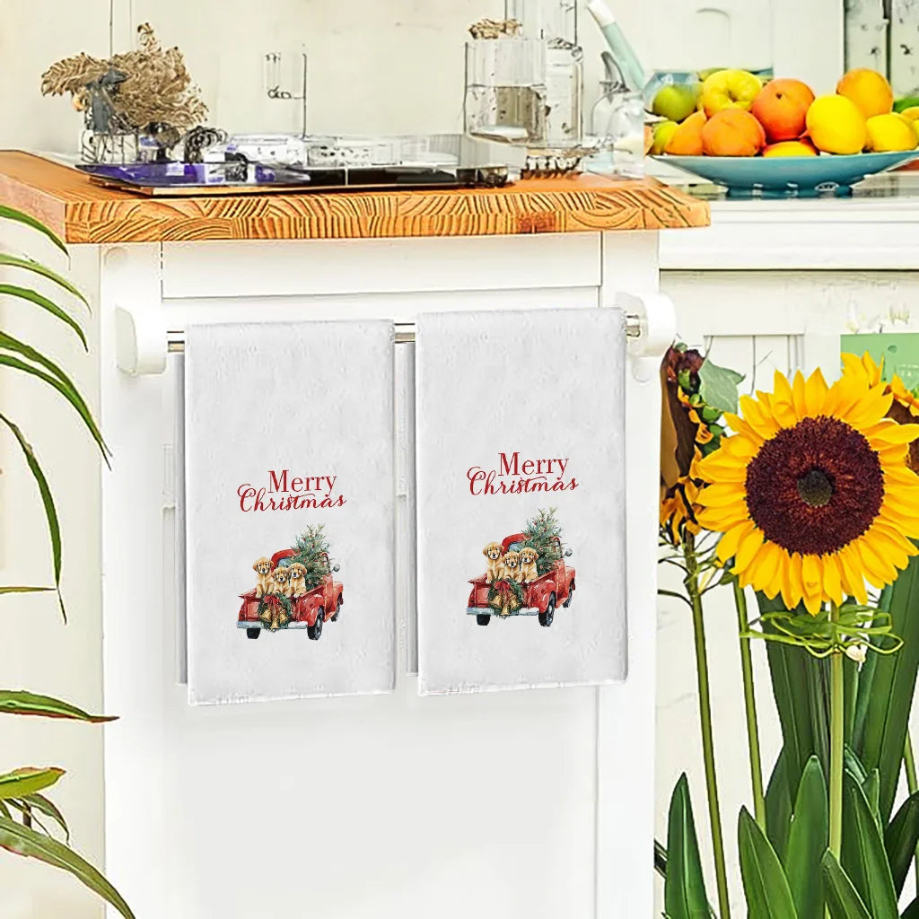 A set of two white kitchen towels featuring festive Merry Christmas designs with dogs and trucks.