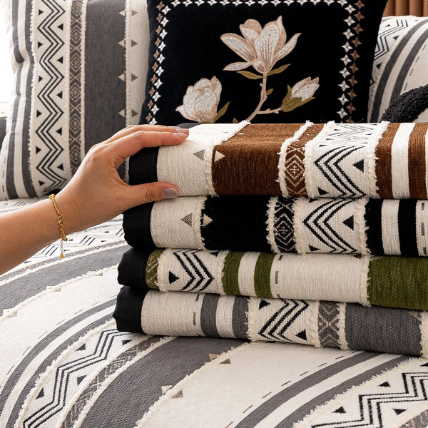 Stack of bohemian chenille sofa cushion covers featuring geometric patterns in brown, black, white, and olive green.