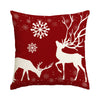 A red pillow featuring a white deer silhouette and snowflakes.
