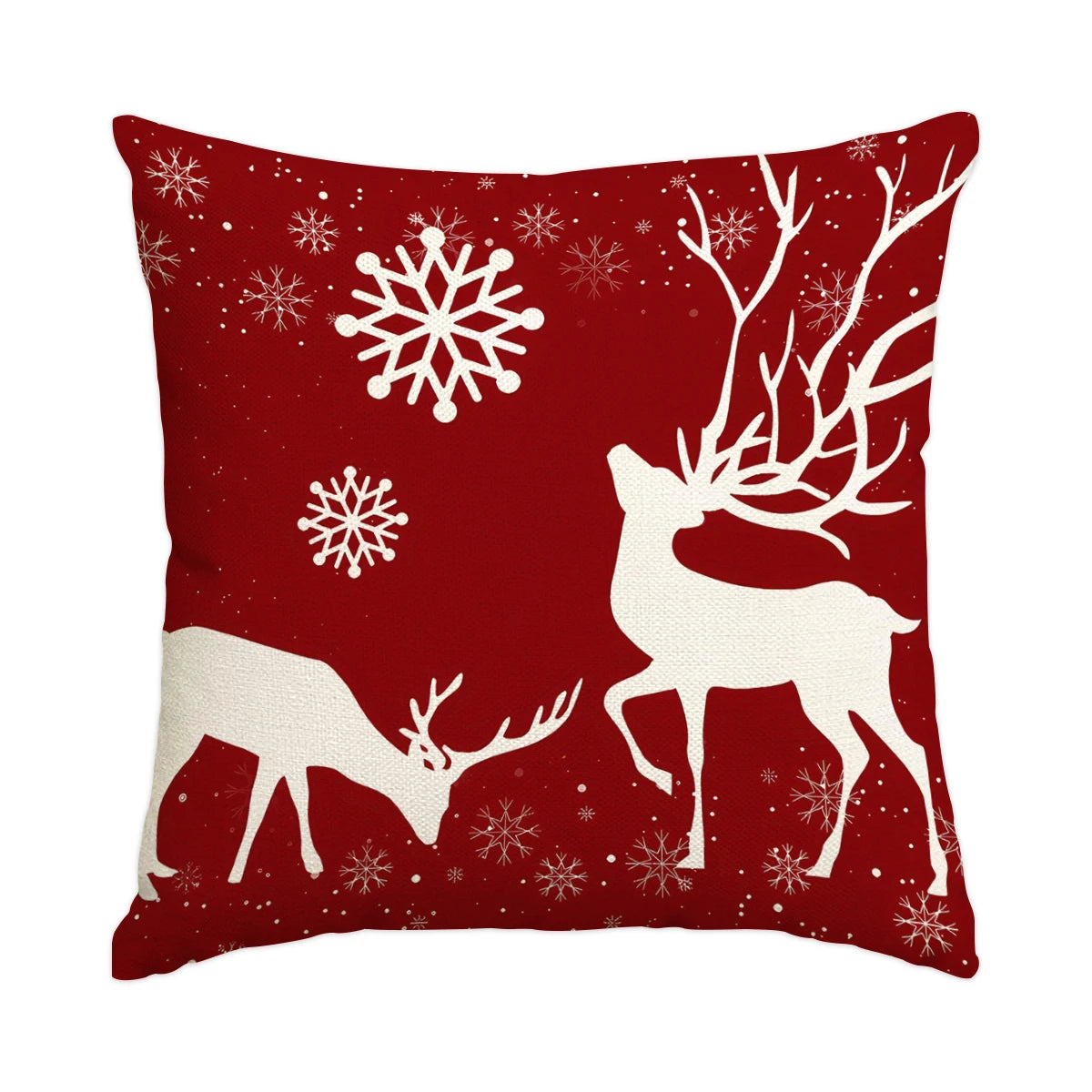 A red pillow featuring a white deer silhouette and snowflakes.