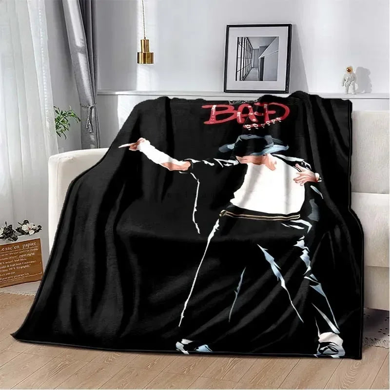 A black flannel blanket featuring a graphic design of a man with a hat and red text on his shirt.