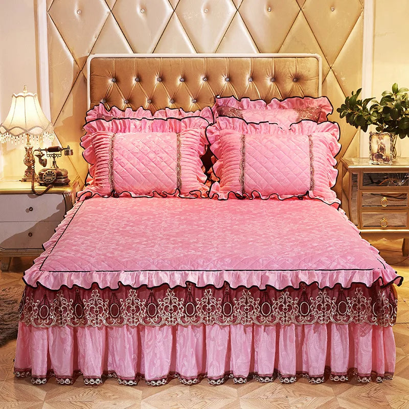 Pink quilted bed skirt set with matching pillowcases and a pink quilted bedspread.