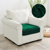 A white upholstered armchair with a dark green velvet seat cover and a decorative green fabric accent.