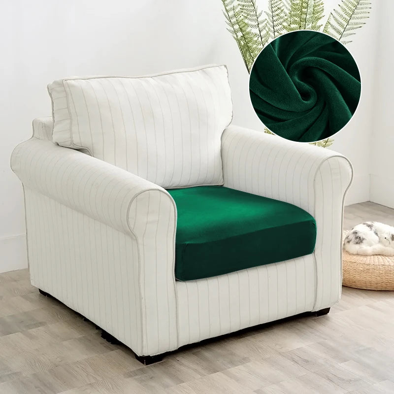 A white upholstered armchair with a dark green velvet seat cover and a decorative green fabric accent.