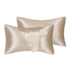 A pair of silky satin pillow covers in a champagne or beige color.